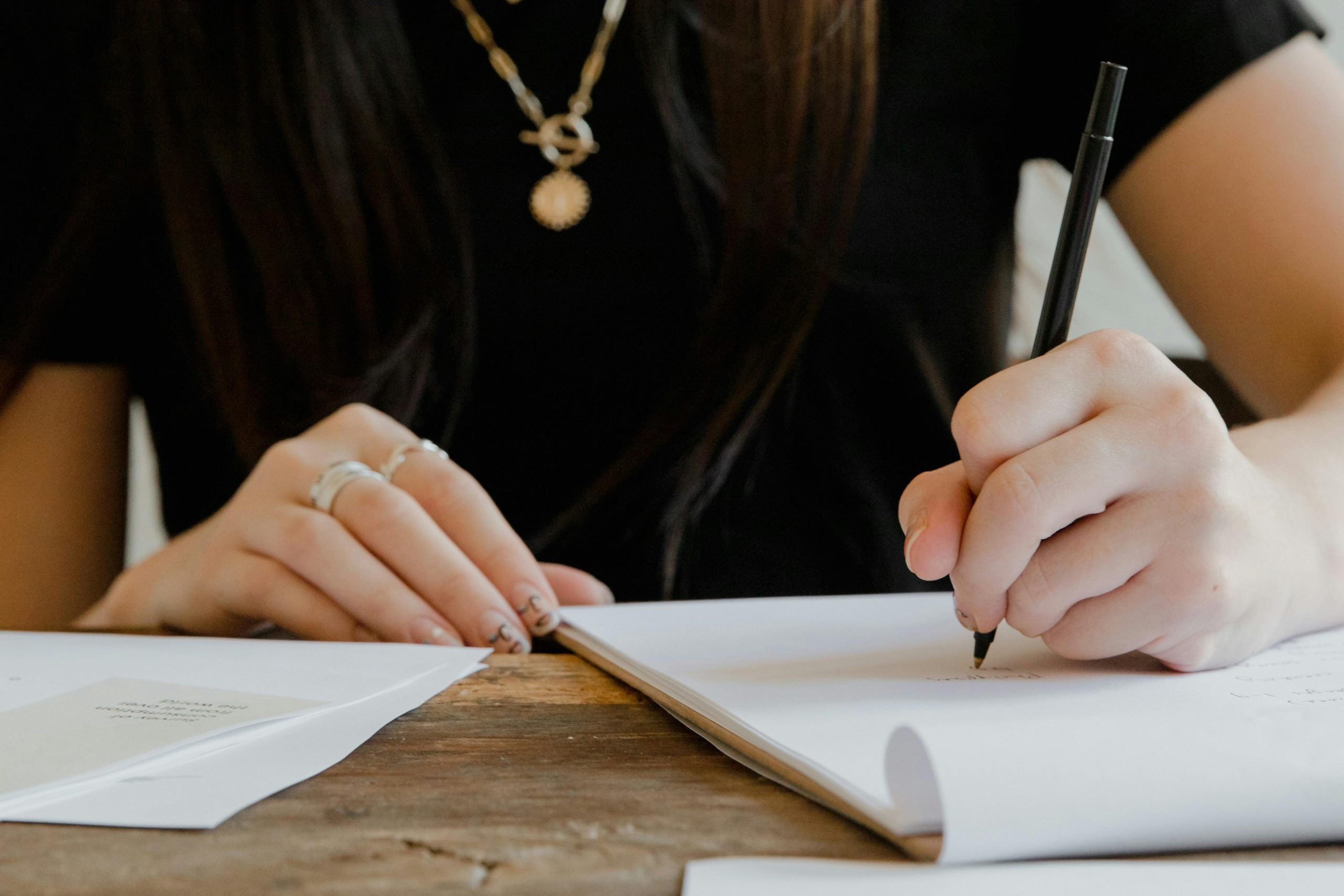 person writing decision journal notebook reflection desk